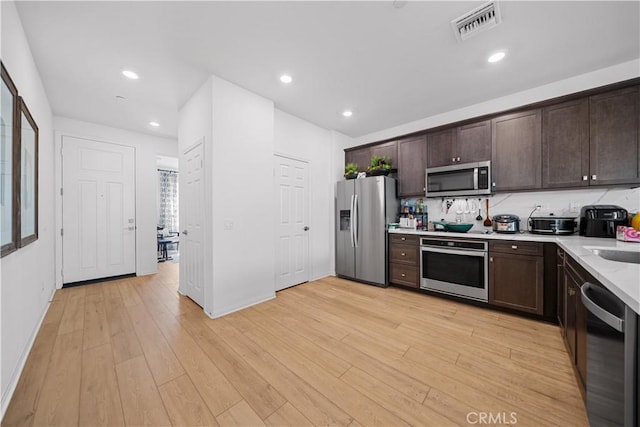 kitchen with light countertops, dark brown cabinets, visible vents, and appliances with stainless steel finishes