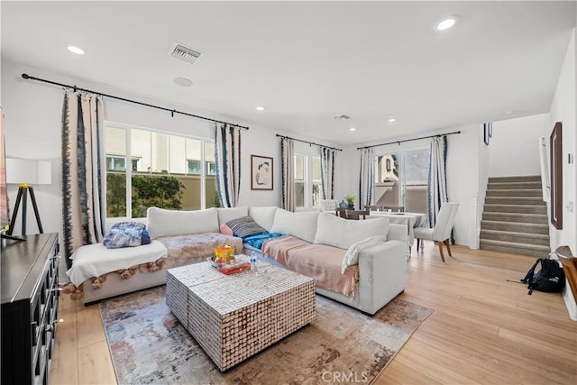 living room featuring stairway, recessed lighting, visible vents, and light wood-type flooring