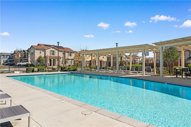 pool featuring a patio, fence, and a residential view