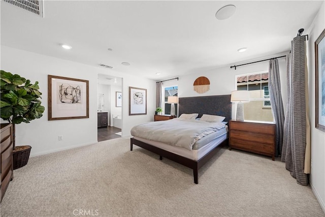 bedroom featuring visible vents, ensuite bathroom, baseboards, and carpet floors