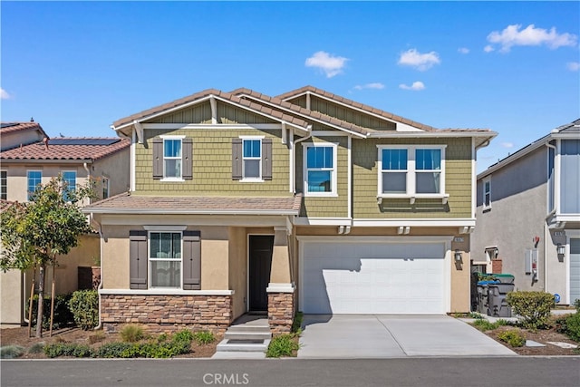 view of front of home featuring a tiled roof, stucco siding, a garage, stone siding, and driveway