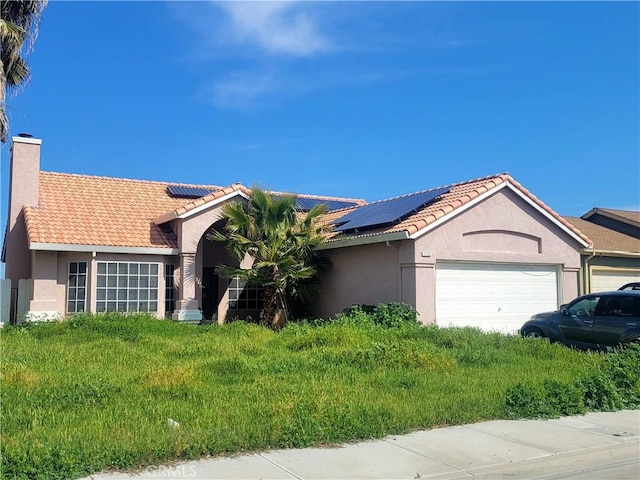 ranch-style home with stucco siding, a garage, a chimney, and a tiled roof