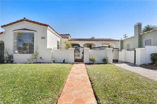 mediterranean / spanish-style home with a tiled roof, a gate, a fenced front yard, and stucco siding