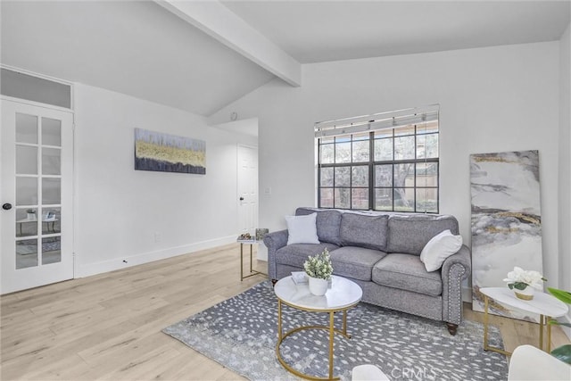 living room featuring vaulted ceiling with beams, baseboards, and wood finished floors