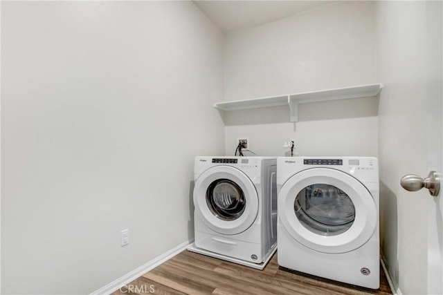 washroom with laundry area, wood finished floors, independent washer and dryer, and baseboards