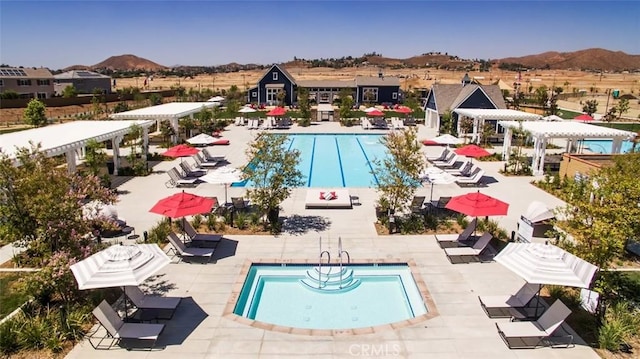 pool with a mountain view, a pergola, and a patio