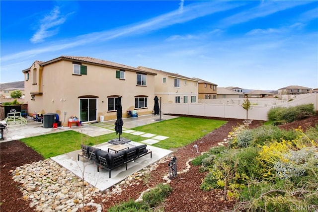 back of property with a patio area, stucco siding, a lawn, and a fenced backyard