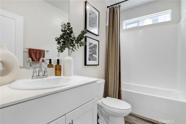 bathroom featuring vanity, toilet, wood finished floors, and shower / bath combo