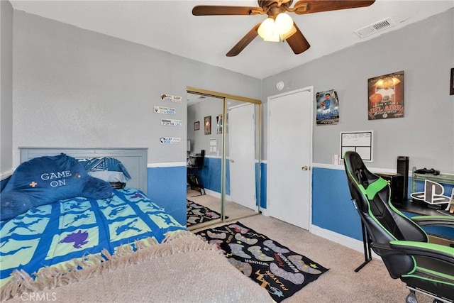 carpeted bedroom with visible vents, baseboards, a closet, and ceiling fan