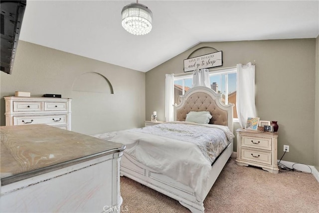 carpeted bedroom with an inviting chandelier, vaulted ceiling, and baseboards