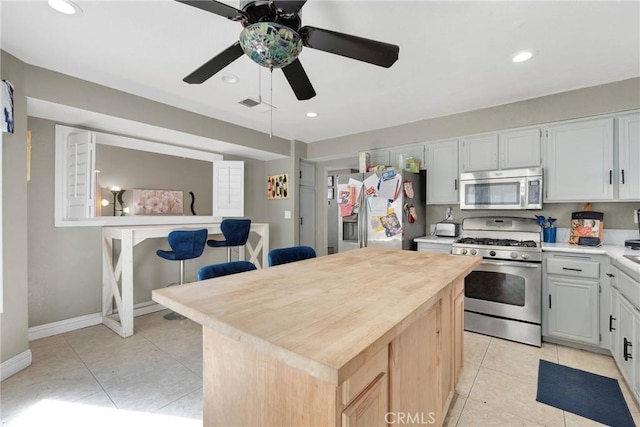 kitchen featuring visible vents, a kitchen island, light tile patterned floors, recessed lighting, and appliances with stainless steel finishes