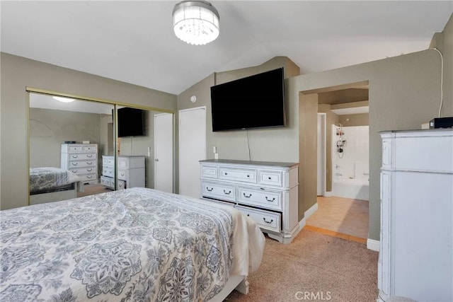 bedroom with a closet, lofted ceiling, and light colored carpet