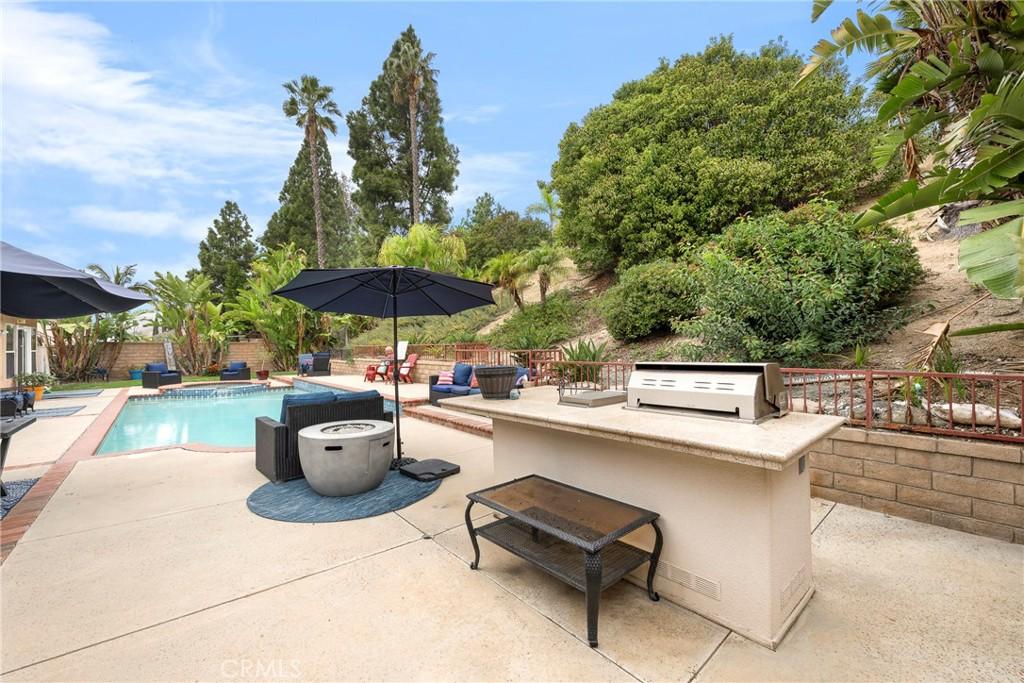 view of swimming pool featuring a patio area, a grill, exterior kitchen, and a fenced backyard