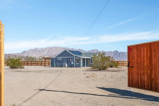 exterior space featuring solar panels, fence private yard, and a mountain view