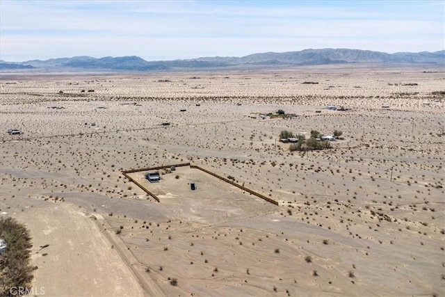 birds eye view of property featuring a mountain view, a rural view, and view of desert