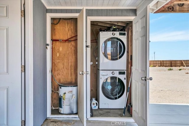 washroom featuring laundry area, wood walls, and stacked washing maching and dryer