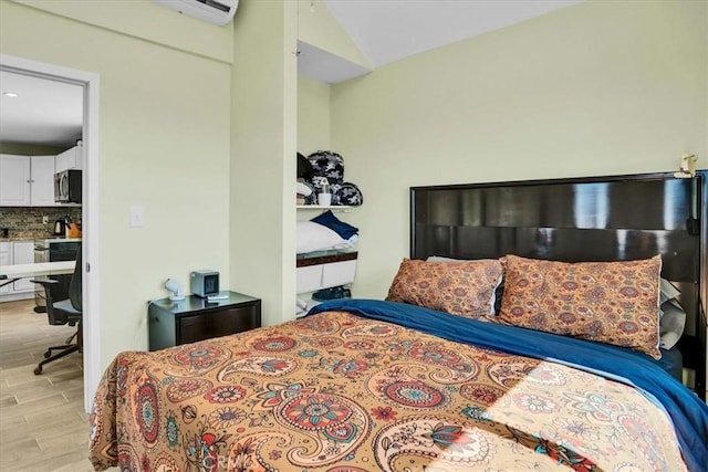 bedroom featuring light wood-style flooring and vaulted ceiling