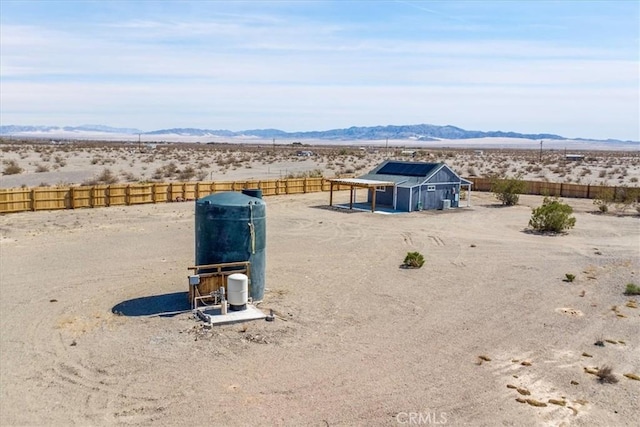 exterior space featuring a mountain view, a desert view, and fence