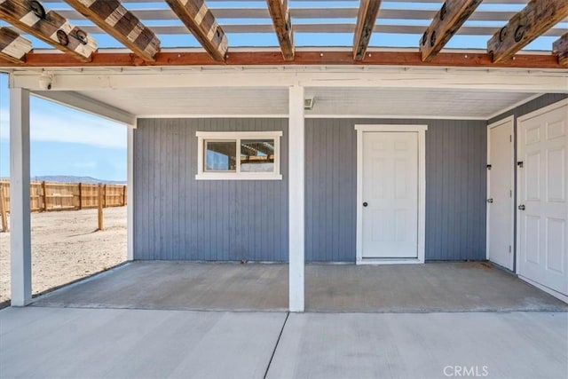 entrance to property featuring fence and a pergola