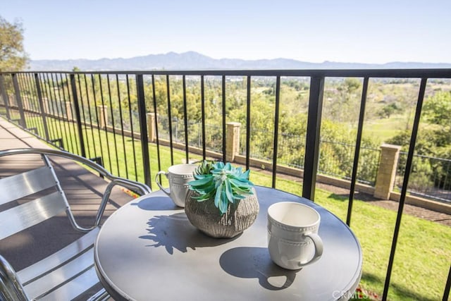 balcony featuring a mountain view and outdoor dining area