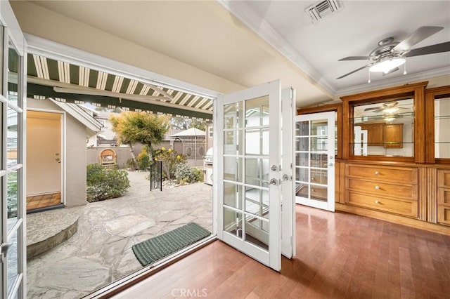 doorway with a ceiling fan, visible vents, ornamental molding, hardwood / wood-style flooring, and french doors