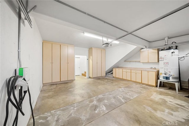 garage with secured water heater, a garage door opener, and a sink