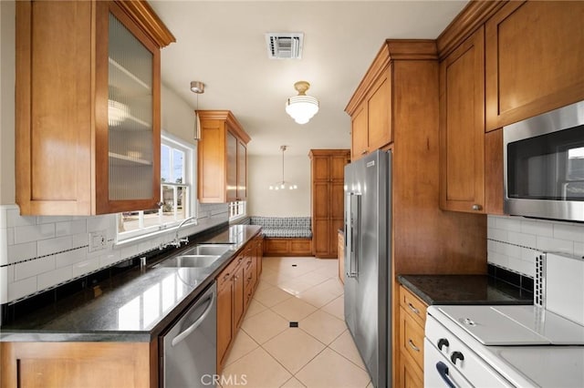 kitchen featuring a sink, brown cabinets, visible vents, and stainless steel appliances