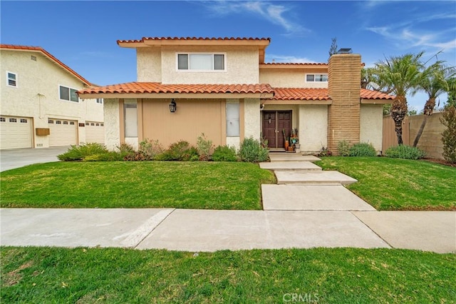 mediterranean / spanish home with an attached garage, a chimney, concrete driveway, and a front yard