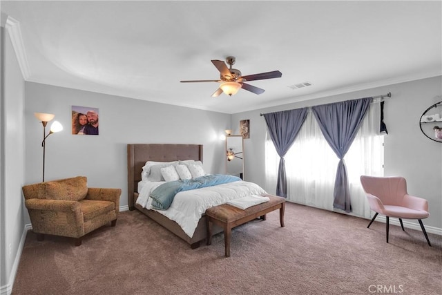 carpeted bedroom featuring visible vents, baseboards, a ceiling fan, and ornamental molding