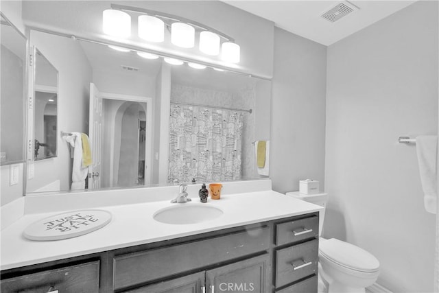 bathroom with vanity, toilet, a shower with curtain, and visible vents