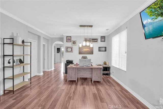 home office featuring baseboards, arched walkways, wood finished floors, and ornamental molding