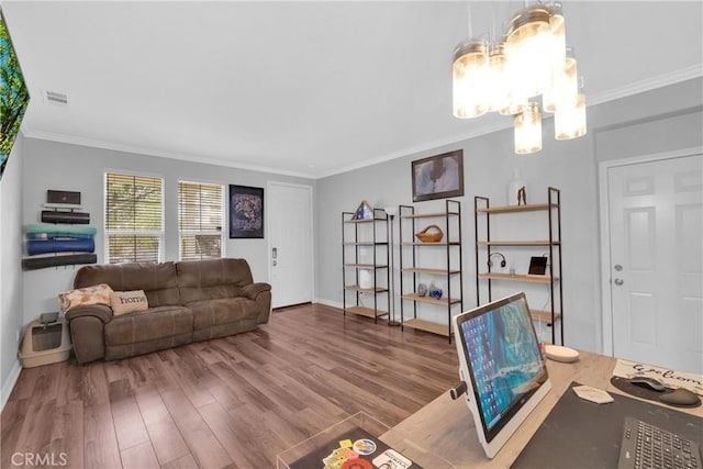 living area with visible vents, ornamental molding, wood finished floors, baseboards, and a chandelier