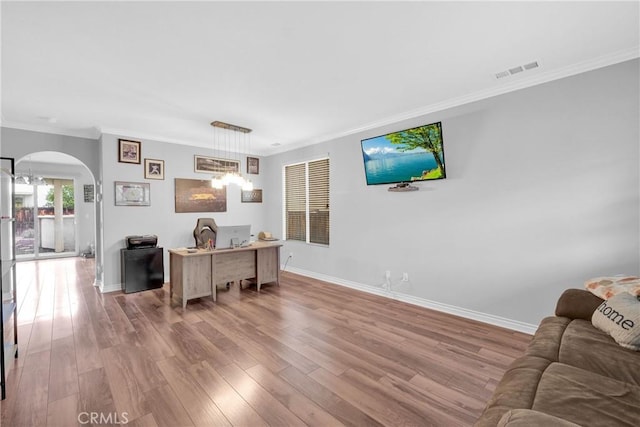 home office with wood finished floors, visible vents, baseboards, arched walkways, and crown molding