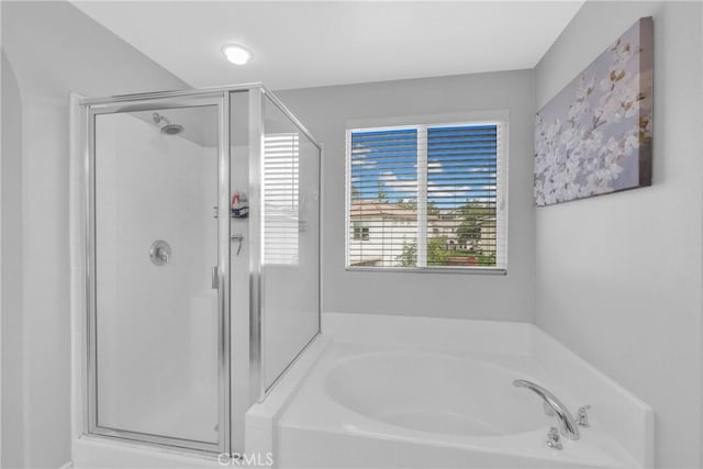 bathroom with a shower stall and a garden tub