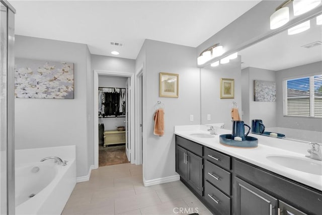 bathroom with a garden tub, visible vents, and a sink