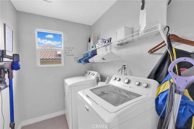 washroom with laundry area, washing machine and dryer, and baseboards