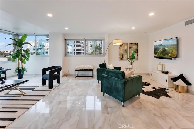 living area with recessed lighting, visible vents, and baseboards