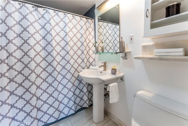 bathroom featuring tile patterned flooring, toilet, and a shower with curtain