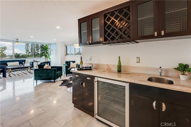 kitchen with glass insert cabinets, open floor plan, beverage cooler, and light countertops