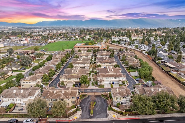 aerial view at dusk featuring a residential view and a mountain view