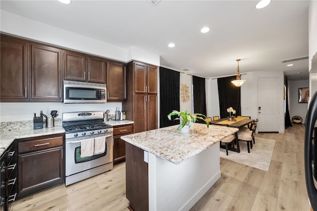 kitchen featuring light wood-style floors, appliances with stainless steel finishes, and dark brown cabinetry