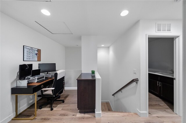 office with visible vents, light wood-type flooring, a sink, recessed lighting, and baseboards