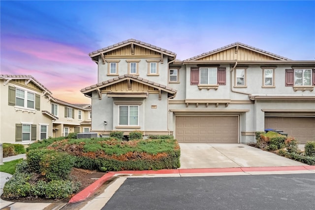 townhome / multi-family property featuring stucco siding, concrete driveway, an attached garage, and a tile roof