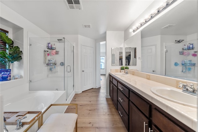 22331 Blue Lupine Cir, Grand Terrace, CA 92313 - bathroom featuring wood finished floors, a stall shower, a garden tub, and double vanity