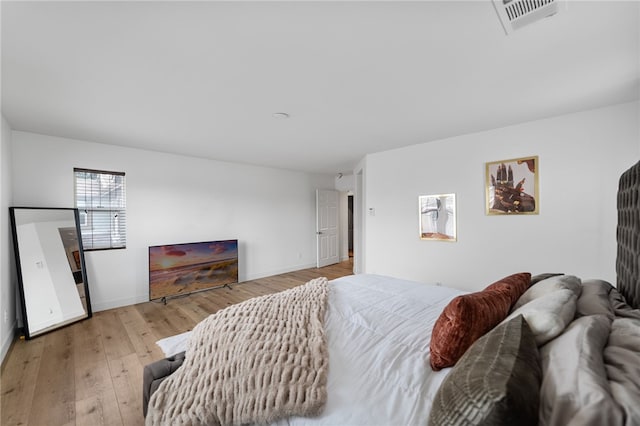 bedroom featuring visible vents, baseboards, and wood-type flooring