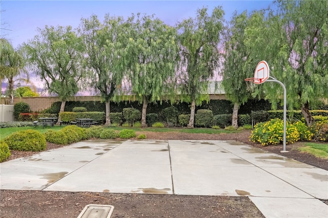 view of patio with community basketball court and fence