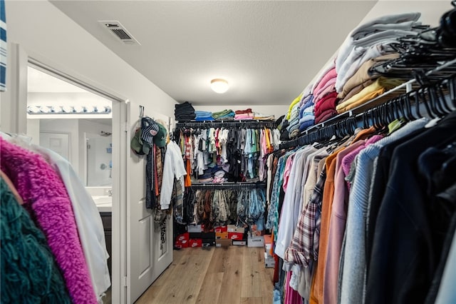 spacious closet featuring visible vents and wood finished floors