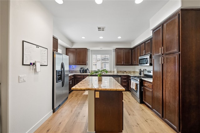 kitchen featuring dark brown cabinets, light wood-style floors, visible vents, and stainless steel appliances