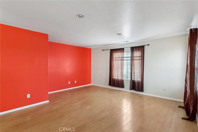 unfurnished room featuring baseboards and wood finished floors