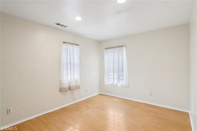 spare room featuring recessed lighting, baseboards, visible vents, and light wood-type flooring